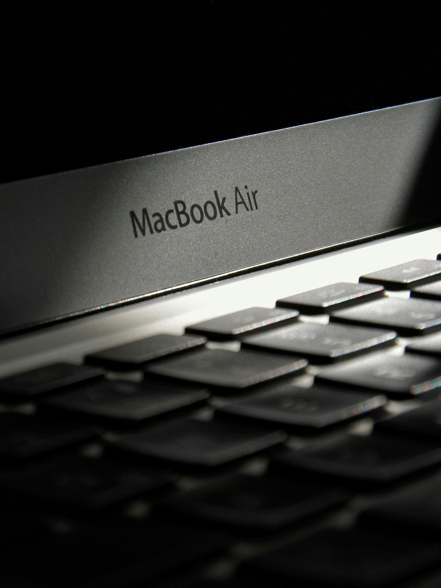 Artistic black and white close-up photo of a MacBook Air keyboard, highlighting modern design.
